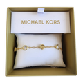 Pulsera Michael Kors dorada con dijes y cristales elegantes