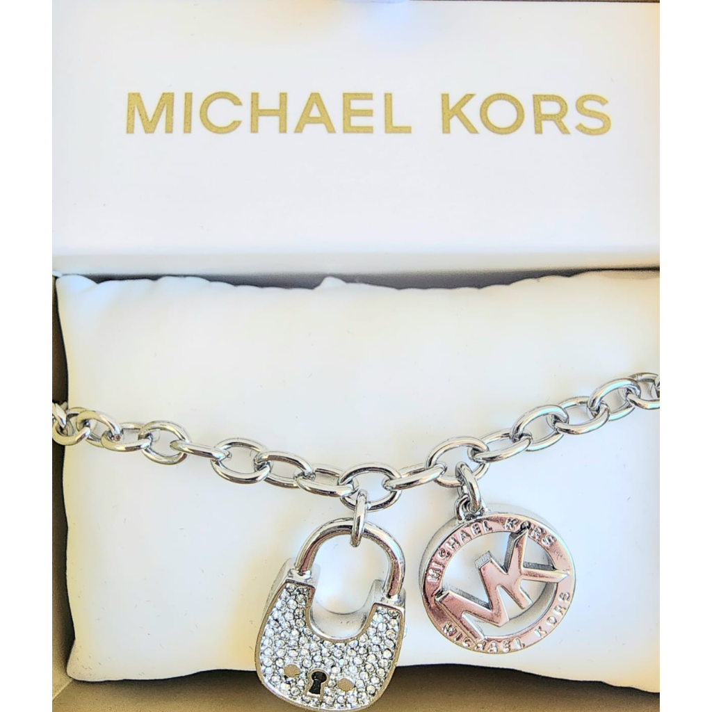 Pulsera Michael Kors plateada con dijes candado y logo MK con cristales