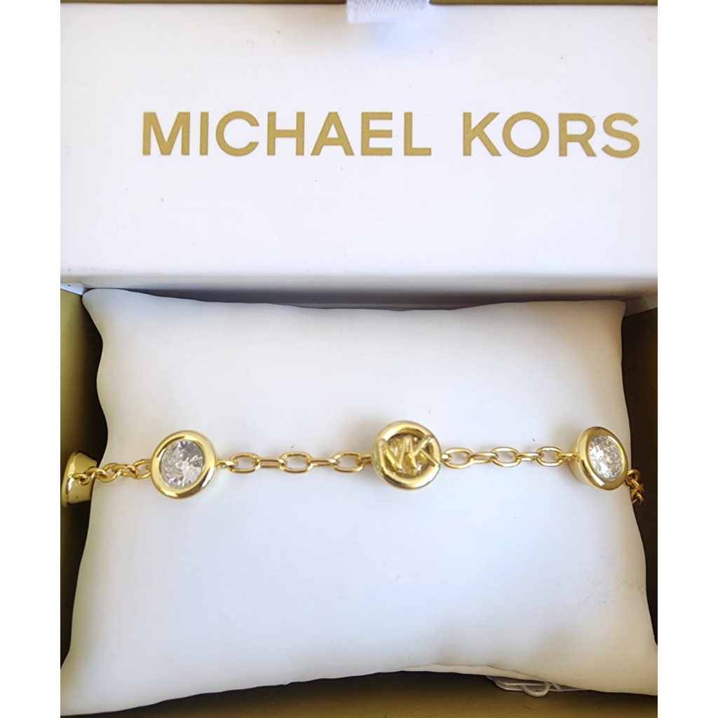 Pulsera Michael Kors dorada con dijes y cristales elegantes