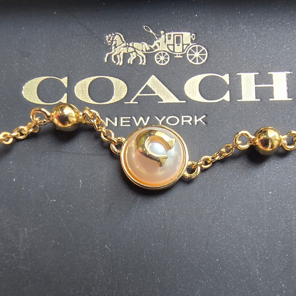 Pulsera Coach Dorada con Perlas Ajustable y Elegante