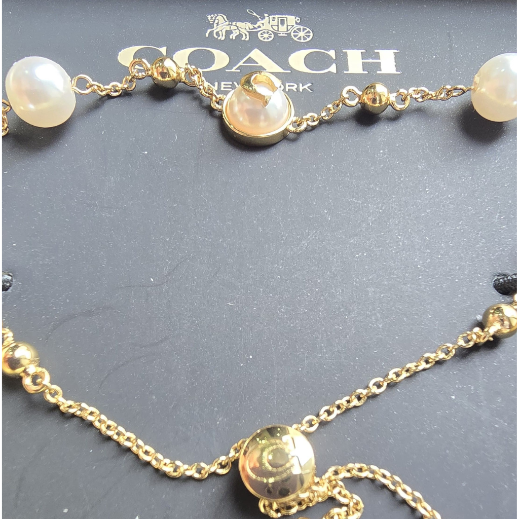 Pulsera Coach Dorada con Perlas Ajustable y Elegante